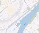 Map showing a river labeled Syv Sluizen with adjacent road networks and a harbor area. The river runs horizontally, with various parallel streets and blocks depicted in light colors on both sides.